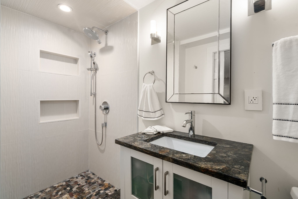 14 Sunset Road Wellesley, MA 02482 - Photo 27 of 39 a bathroom with a granite countertop sink a mirror and shower