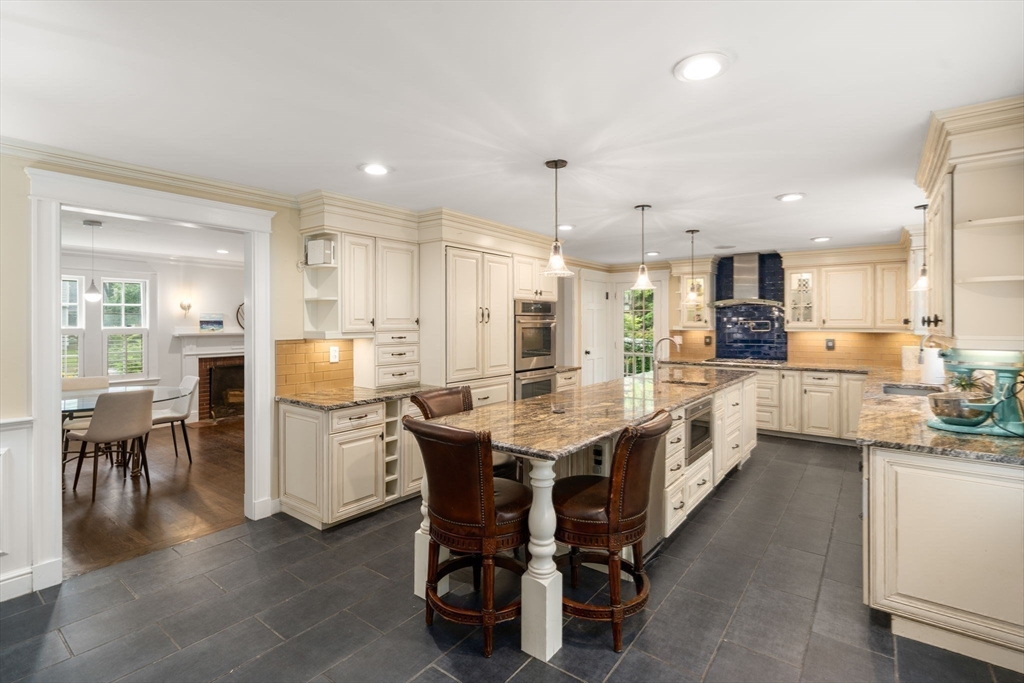 14 Sunset Road Wellesley, MA 02482 - Photo 10 of 39 a kitchen with stainless steel appliances kitchen island granite countertop a table chairs and a refrigerator