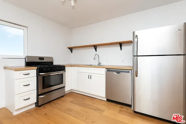 a kitchen with white cabinets and white appliances