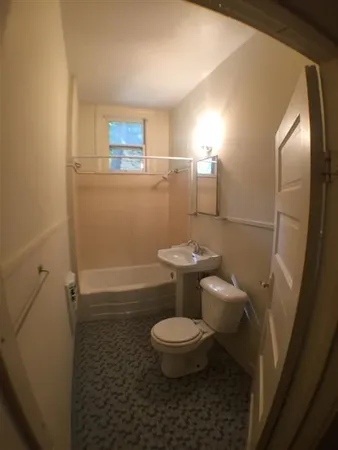 a bathroom with a toilet and a mirror