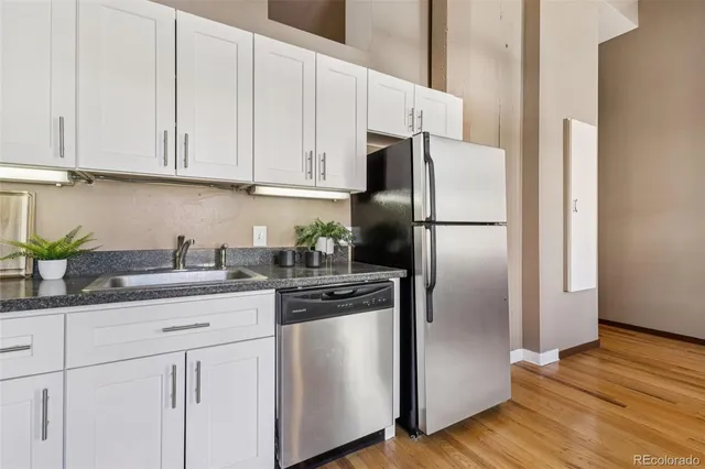 a kitchen with granite countertop white cabinets and stainless steel appliances