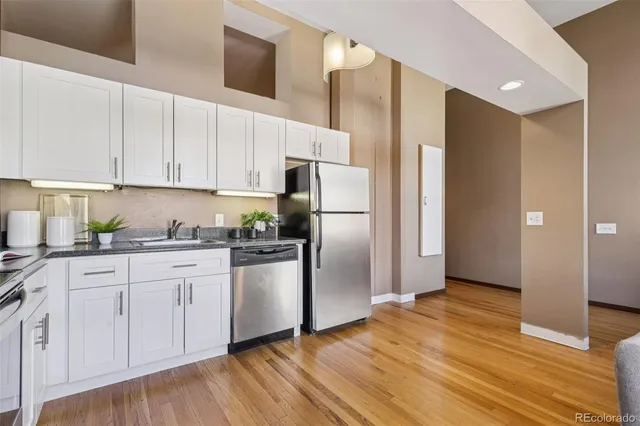 a kitchen with a refrigerator cabinets and wooden floor