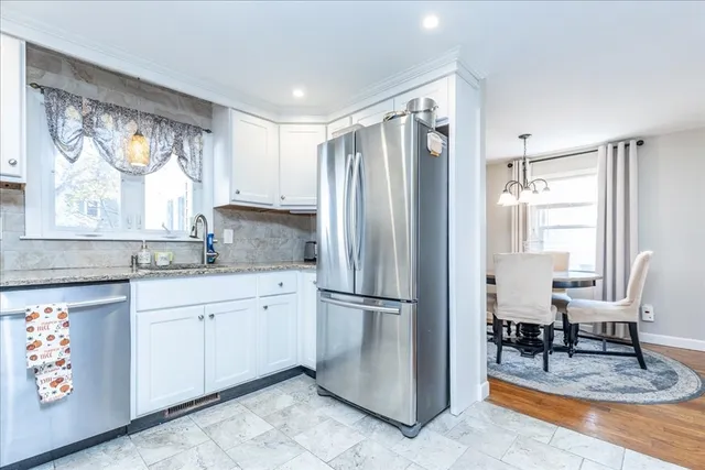 a kitchen with stainless steel appliances granite countertop a refrigerator and a sink