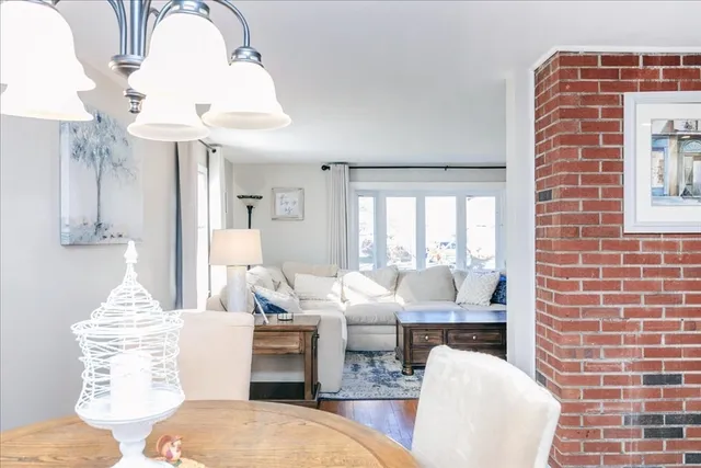 a living room with couches chandelier and a fireplace