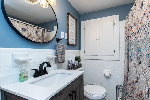 a bathroom with a sink a toilet and a mirror