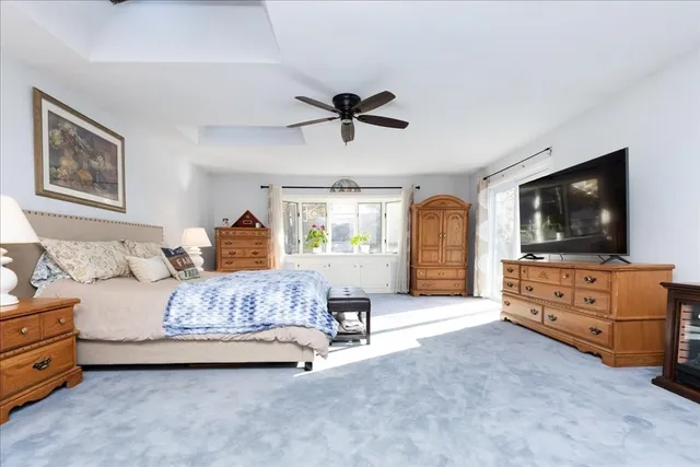 a spacious bedroom with a bed and a flat screen tv