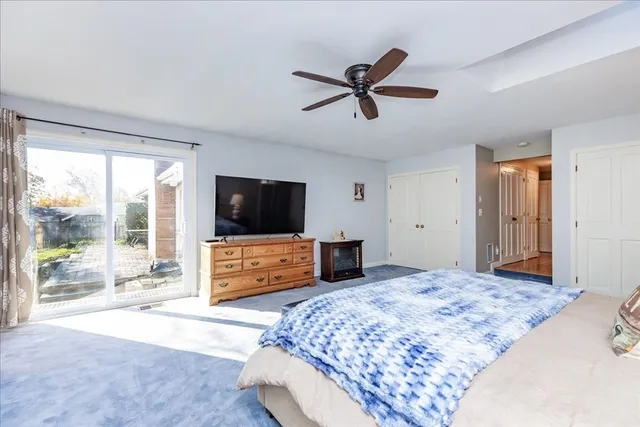 a bedroom with a bed a window and a flat screen television
