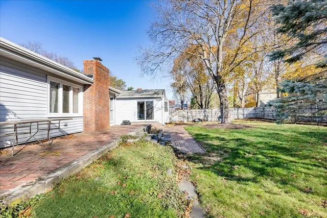 a view of house with backyard and trees