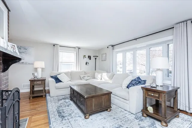 a living room with furniture large windows and a fireplace