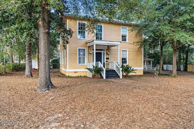 a view of a house with backyard and trees