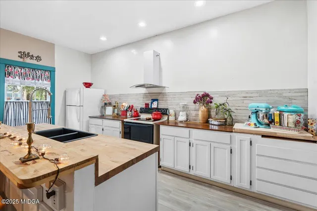 a view of a kitchen with kitchen island a sink stove and refrigerator