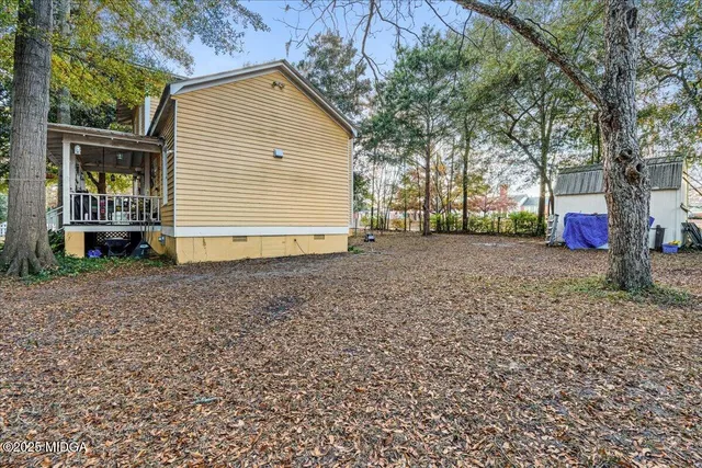 a front view of a house with a yard and trees
