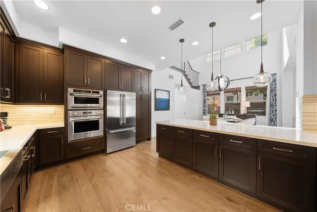 a kitchen with stainless steel appliances kitchen island granite countertop a refrigerator a stove a sink and a microwave