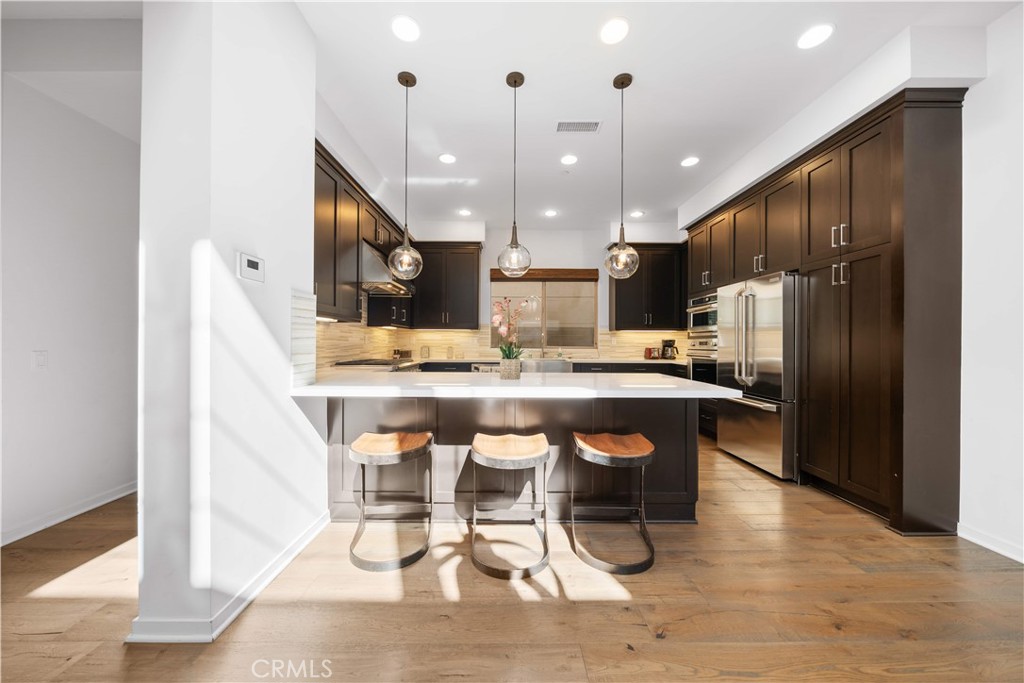 105 Newall Irvine, CA 92618 - Photo 15 of 59 a kitchen with stainless steel appliances kitchen island granite countertop a refrigerator a stove a sink and a microwave