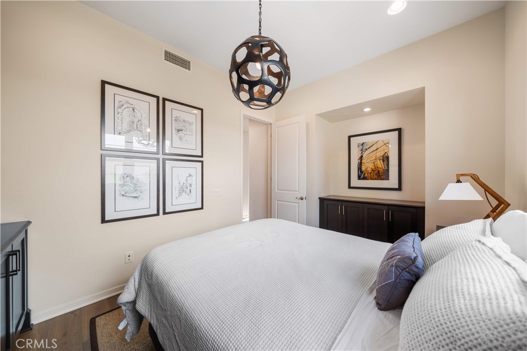 105 Newall Irvine, CA 92618 - Photo 29 of 59 a bedroom with a large bed and a chandelier