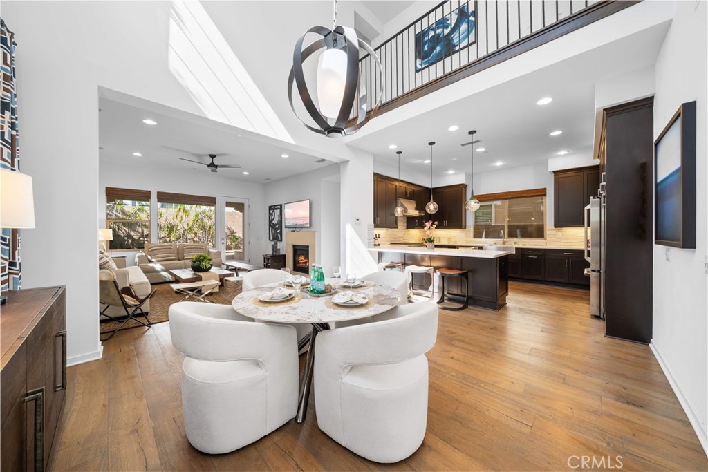 105 Newall Irvine, CA 92618 - Photo 8 of 59 a living room with stainless steel appliances kitchen island granite countertop a large kitchen island a stove a refrigerator a dining table and chairs with wooden floor