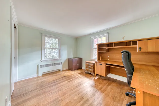 a view of a workspace with furniture and a window