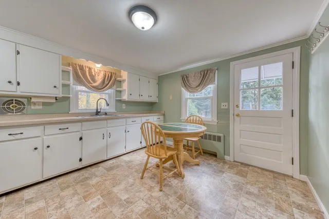 a kitchen with granite countertop white cabinets and white appliances
