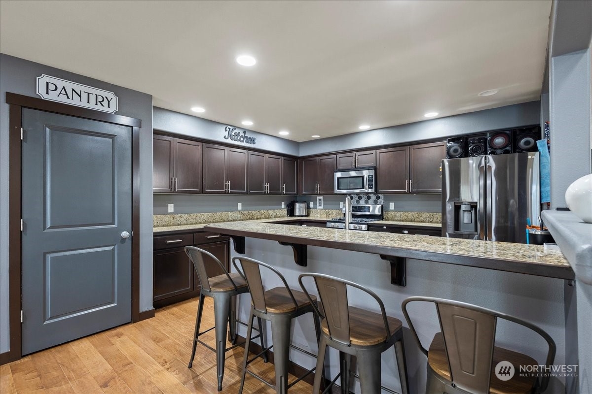 431 Barry Loop Mount Vernon, WA 98274 - Photo 11 of 32 a kitchen with stainless steel appliances granite countertop a table chairs refrigerator and sink