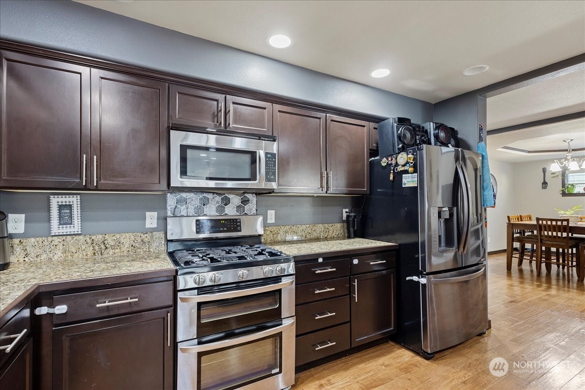 431 Barry Loop Mount Vernon, WA 98274 - Photo 12 of 32 a kitchen with granite countertop a refrigerator stove and microwave