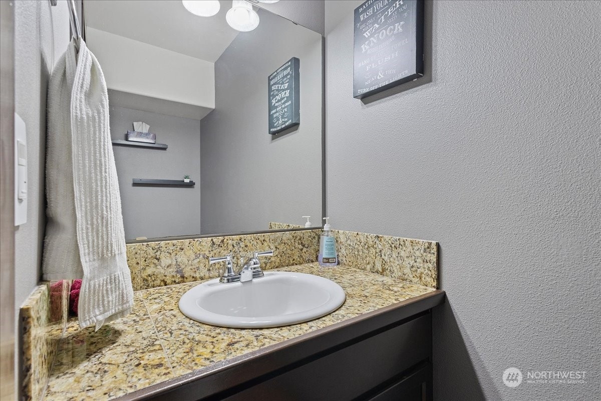 431 Barry Loop Mount Vernon, WA 98274 - Photo 6 of 32 a bathroom with a granite countertop sink and a mirror
