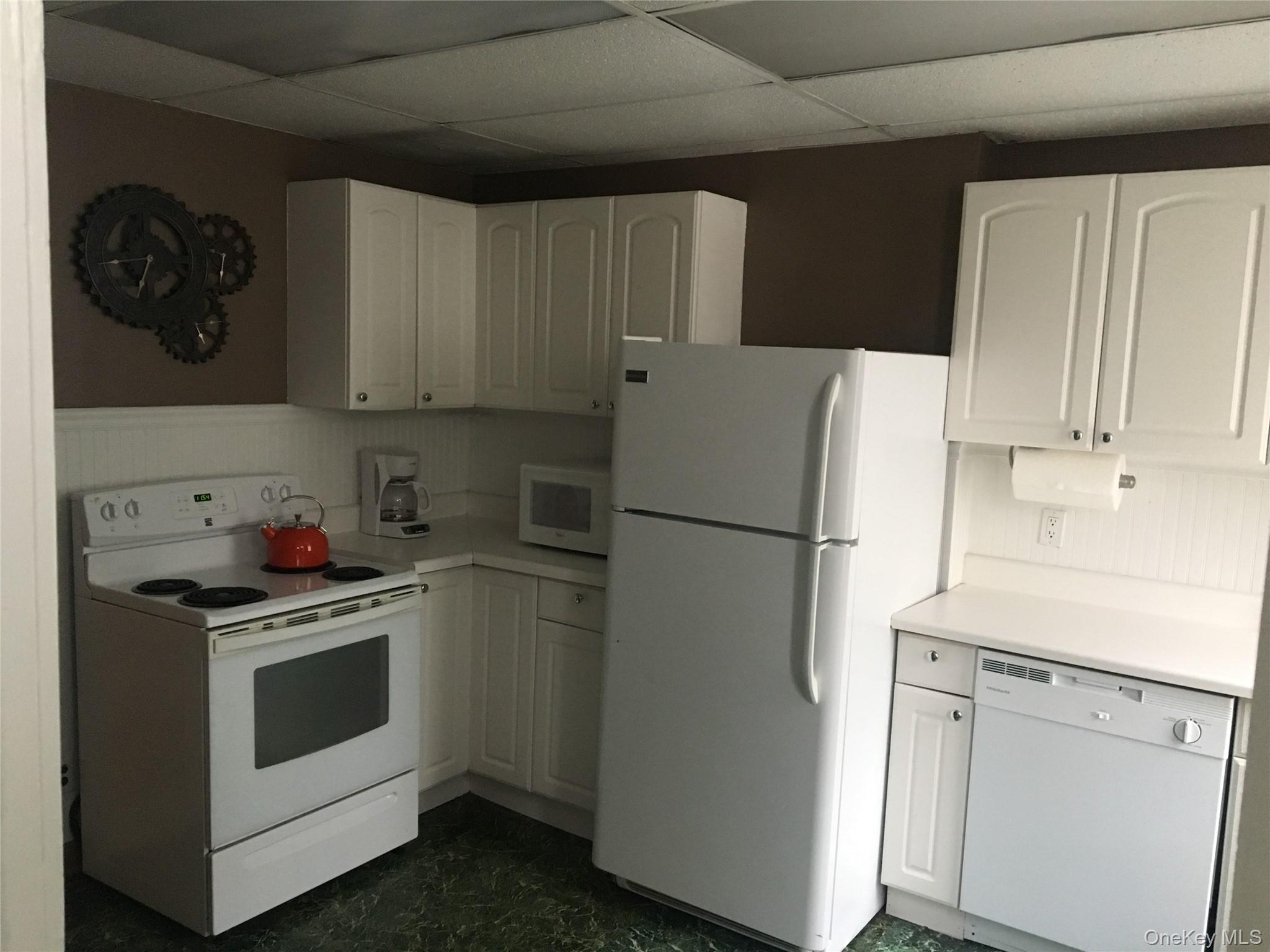 249 Main Street, Unit WEST Huntington, NY 11743 - Photo 6 of 6 a white refrigerator freezer sitting inside of a kitchen