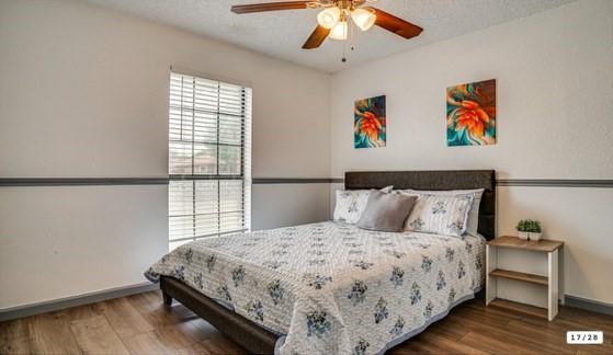 562 Stringfellow Drive Coppell, TX 75019 - Photo 12 of 24 Bedroom featuring wood-finish flooring, a ceiling fan with integrated lighting, and a large window with horizontal blinds