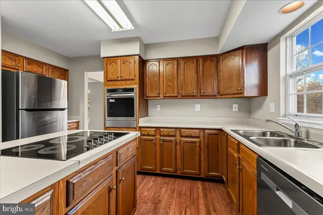 a kitchen that has a sink cabinets counter space and stainless steel appliances