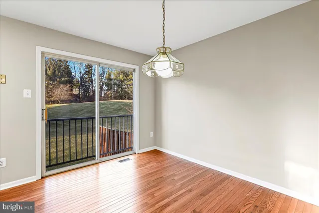 a view of a room with wooden floor fan and windows