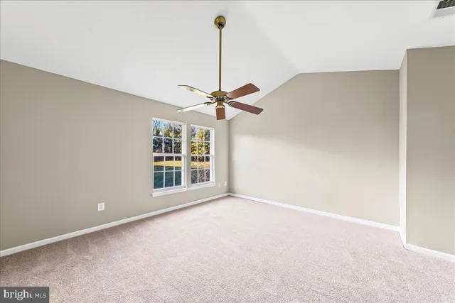a view of a room with a ceiling fan and window