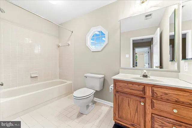 a bathroom with a granite countertop toilet a sink and a bathtub