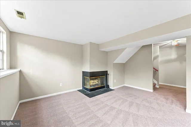 an empty room with a fireplace and wooden floor
