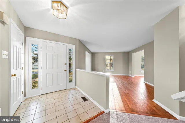 a view of a hallway with wooden floor and a living room