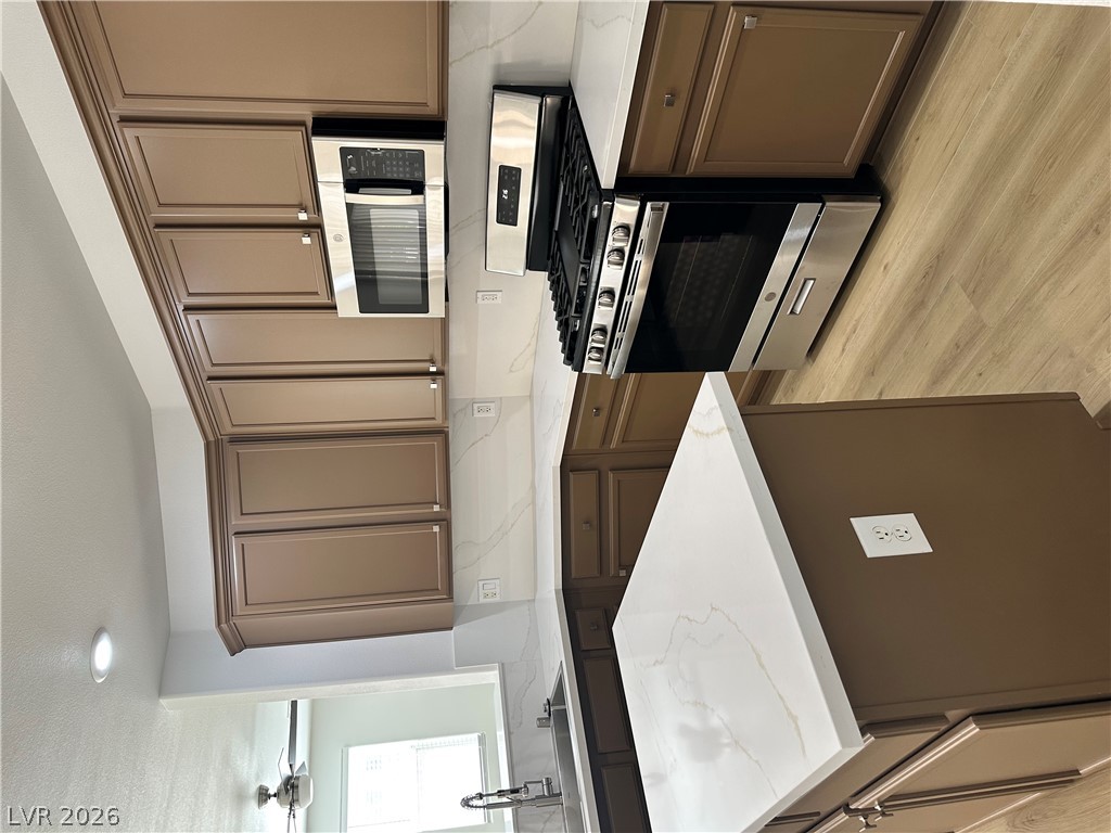 9639 West Post Road Las Vegas, NV 89148 - Photo 10 of 30 Gleaming stone countertops and stainless steel appliances elevate this modern cooking space.