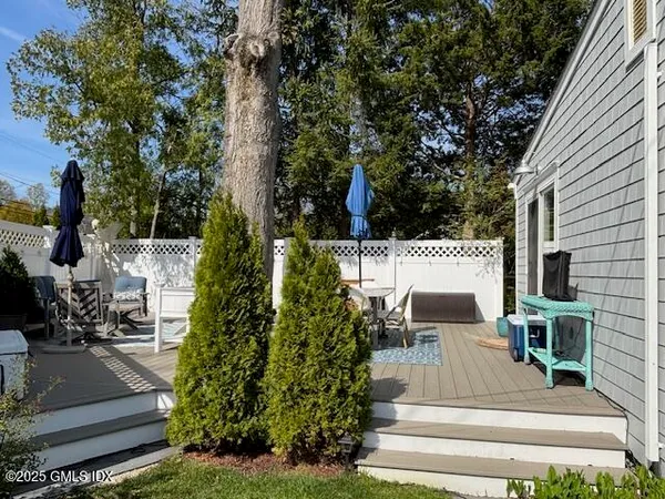 a view of a patio with table and chairs potted plants and large tree