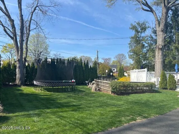 a front view of a house with garden and a tree