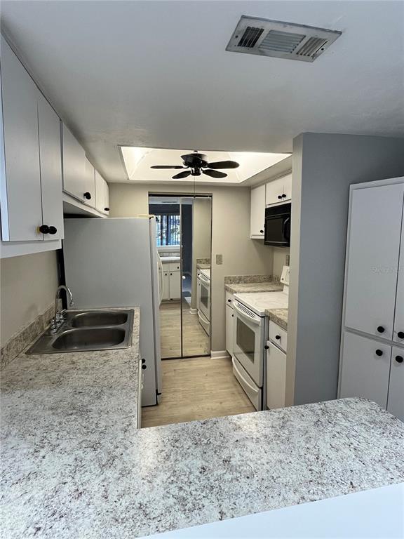 1805 Lennox Road East, Unit 1805 Palm Harbor, FL 34683 - Photo 5 of 15 a kitchen with a sink stainless steel appliances and cabinets