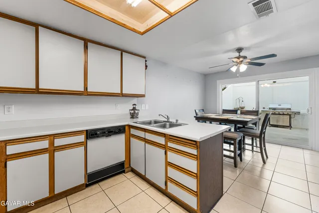 a open kitchen with stainless steel appliances granite countertop a sink a stove top oven a chimney and cabinets