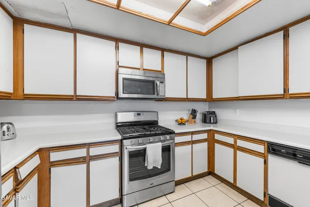 a kitchen with stainless steel appliances granite countertop white cabinets a sink and a stove