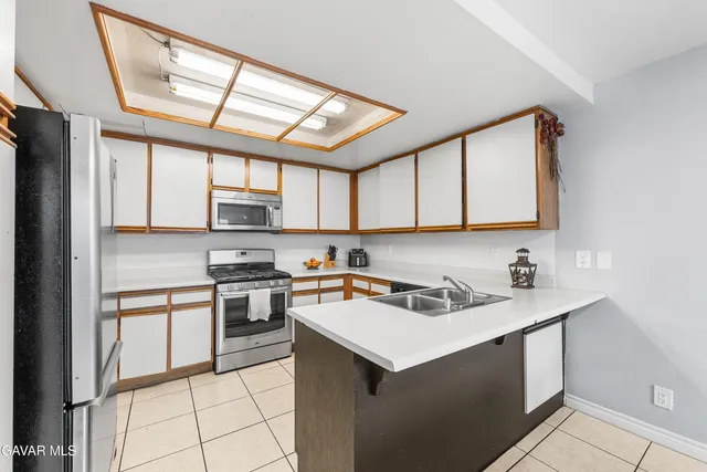 a kitchen with stainless steel appliances granite countertop a sink stove a refrigerator and cabinets