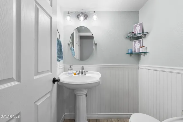 a bathroom with a sink mirror and toilet