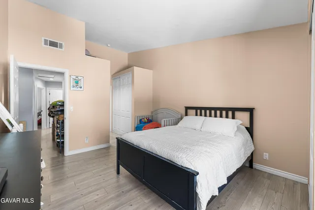 a large bed sitting in a bedroom next to a cabinet
