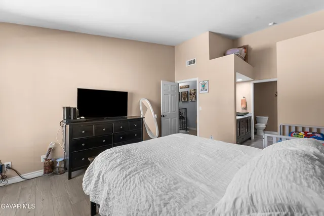 a bedroom with a bed and a flat screen tv