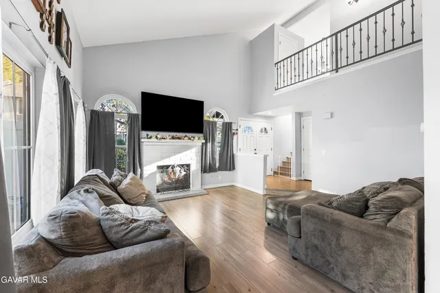 a living room with furniture a flat screen tv and a fireplace