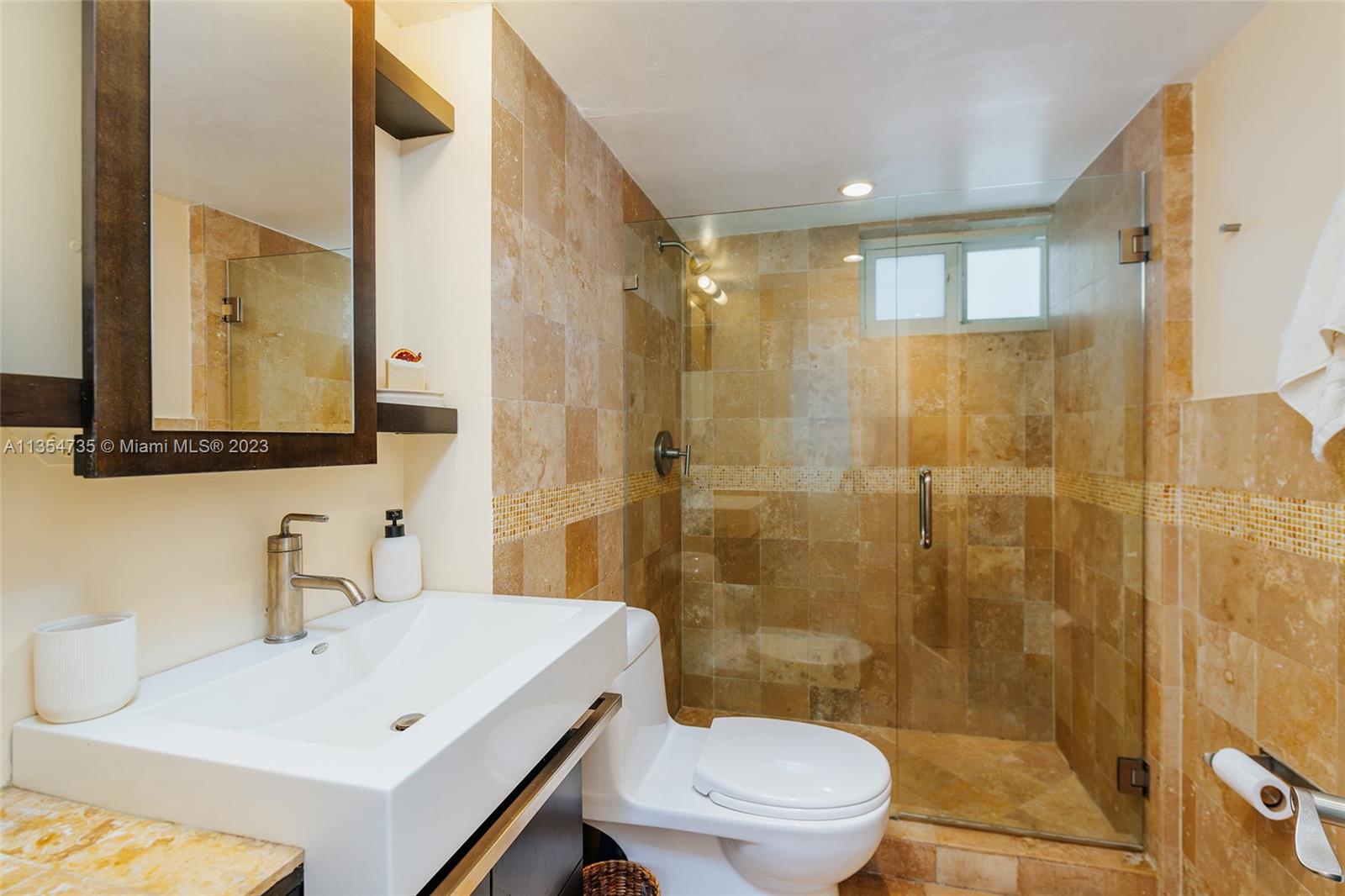 1670 Bay Road, Unit 4F Miami Beach, FL 33139 - Photo 7 of 12 a bathroom with a sink a toilet and shower