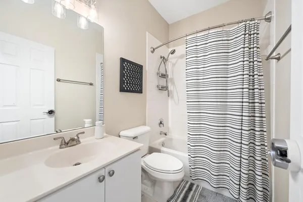 a bathroom with a sink a toilet and shower curtain