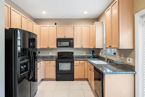 a kitchen with stainless steel appliances granite countertop a refrigerator stove and sink