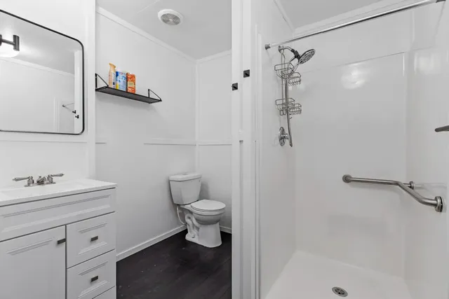 a bathroom with a toilet sink a shower and a mirror