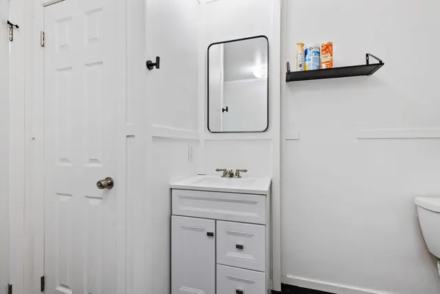 a bathroom with a sink mirror and toilet