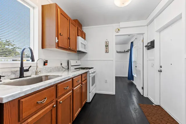 a kitchen with stainless steel appliances granite countertop a sink and a refrigerator